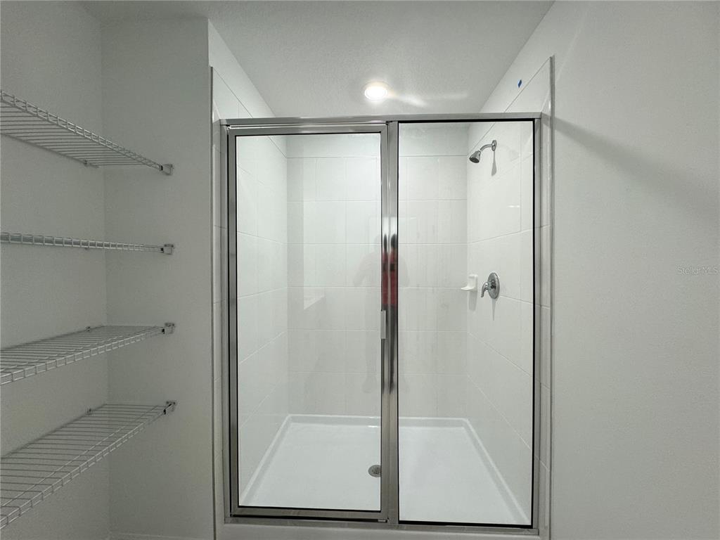 4348 Ranch House Road St. Cloud, FL 34772 - Photo 23 of 58 a bathroom with a glass shower door