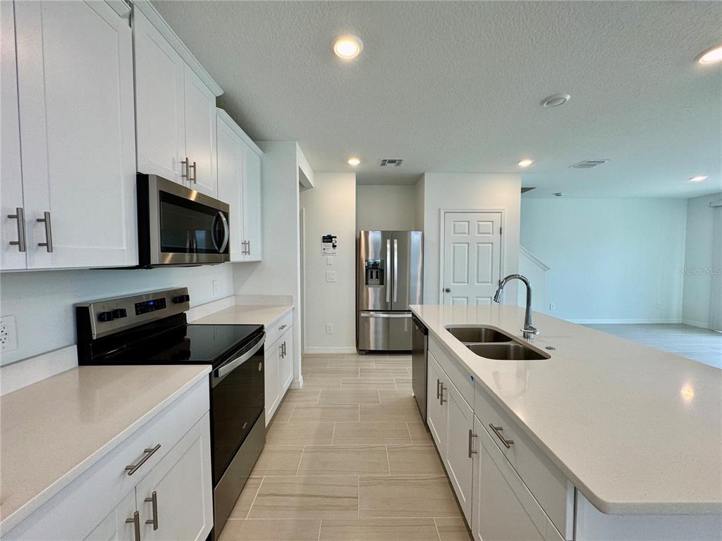 4348 Ranch House Road St. Cloud, FL 34772 - Photo 3 of 58 a kitchen with stainless steel appliances a sink stove and refrigerator