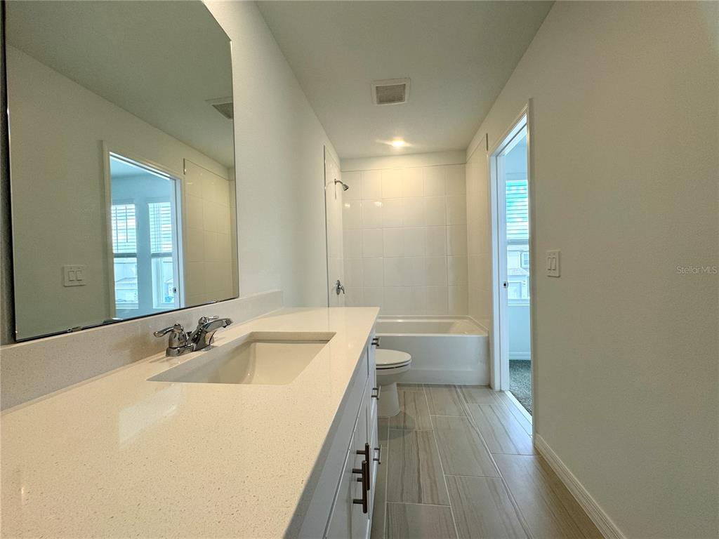 4348 Ranch House Road St. Cloud, FL 34772 - Photo 31 of 58 a bathroom with a sink a mirror and a bathtub