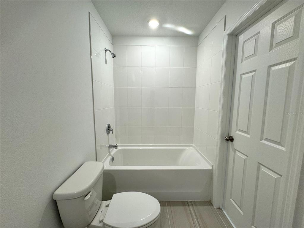 4348 Ranch House Road St. Cloud, FL 34772 - Photo 32 of 58 a bathroom with a toilet and a bathtub