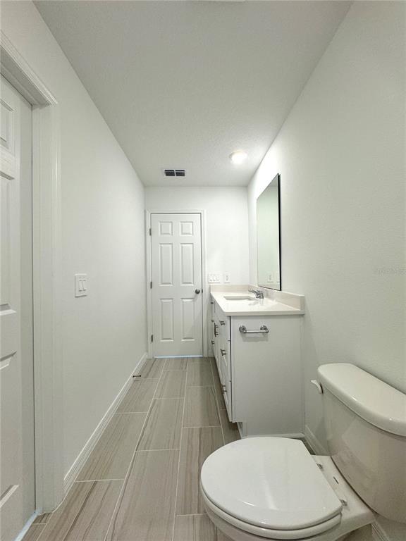 4348 Ranch House Road St. Cloud, FL 34772 - Photo 33 of 58 a white toilet sitting next to a bathroom sink and vanity