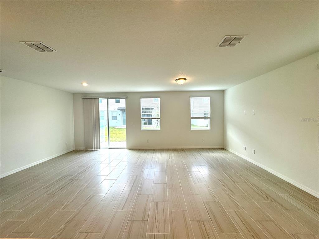 4348 Ranch House Road St. Cloud, FL 34772 - Photo 8 of 58 a view of an empty room with wooden floor and a window