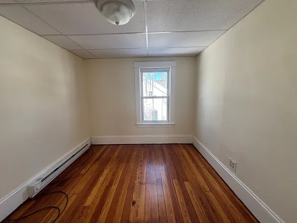 a view of a room with wooden floor and window
