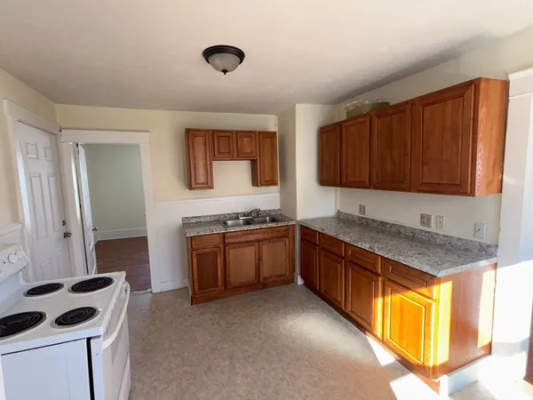 a kitchen with granite countertop a sink stove and cabinets