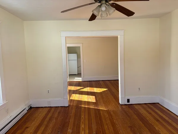 a view of empty room with wooden floor