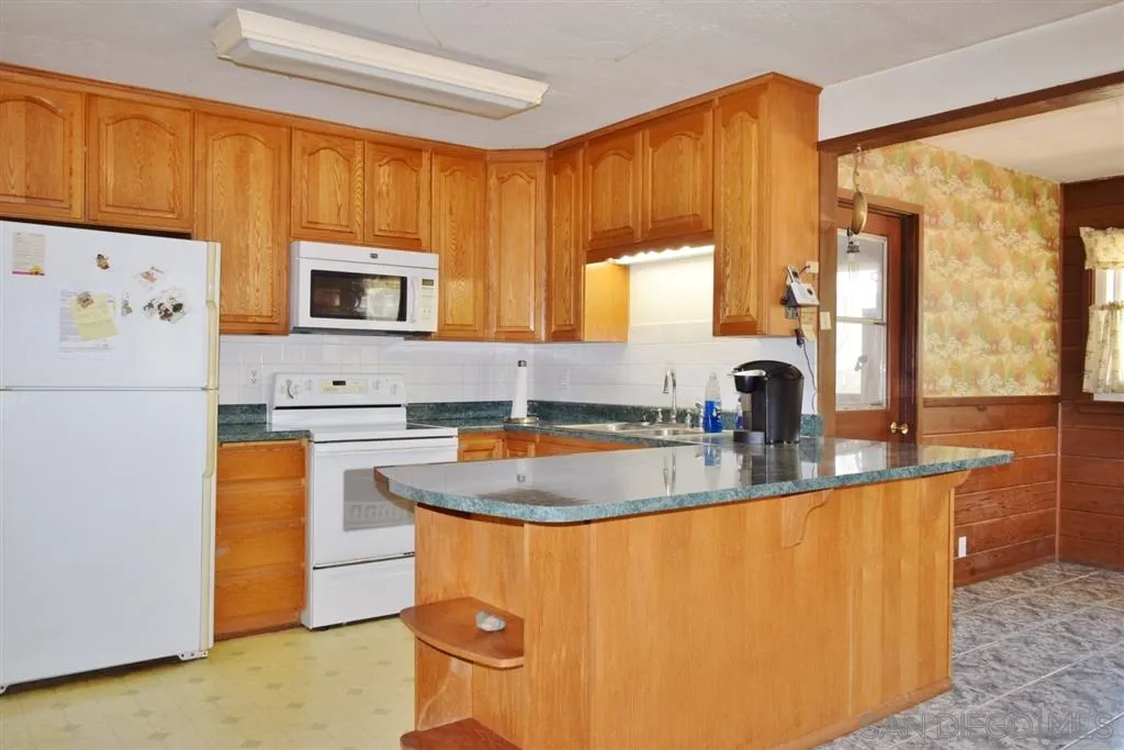 1852 Lilac Road Ramona, CA 92065 - Photo 4 of 25 a kitchen with granite countertop a sink a stove and a refrigerator