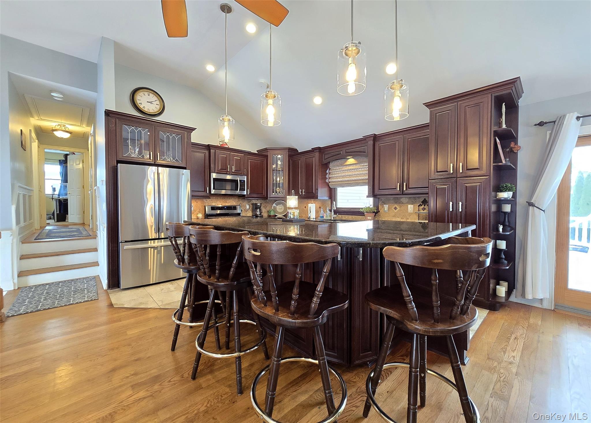 46 Harvest Lane Commack, NY 11725 - Photo 11 of 40 a kitchen with stainless steel appliances granite countertop a dining table chairs refrigerator and microwave