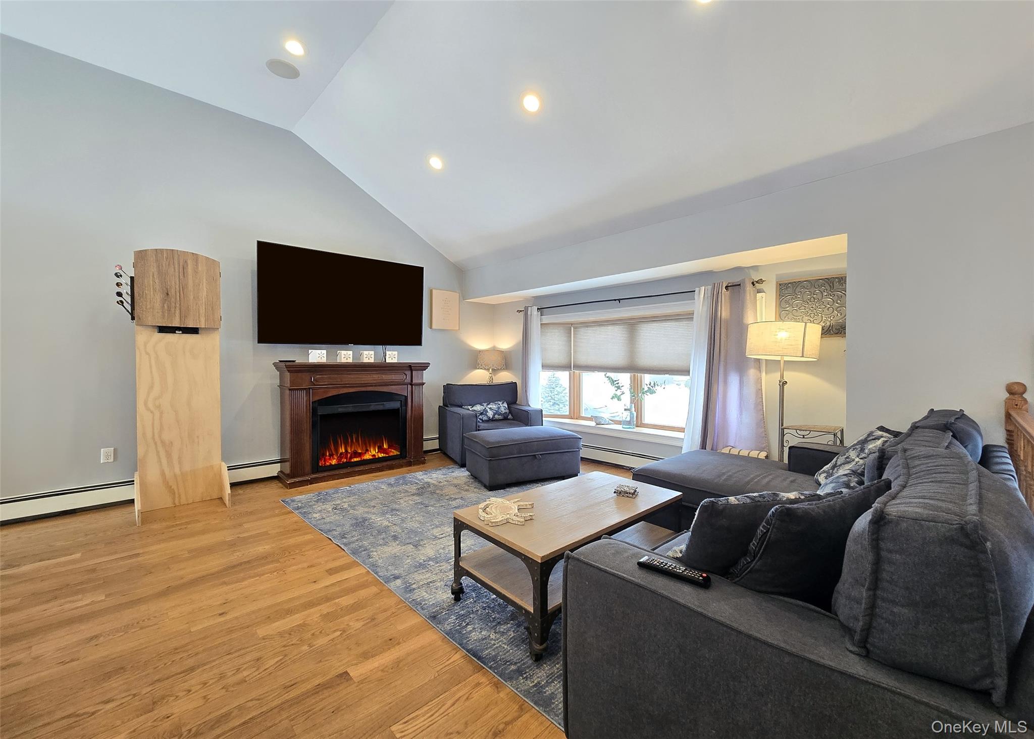 46 Harvest Lane Commack, NY 11725 - Photo 13 of 40 a living room with furniture a flat screen tv and a fireplace