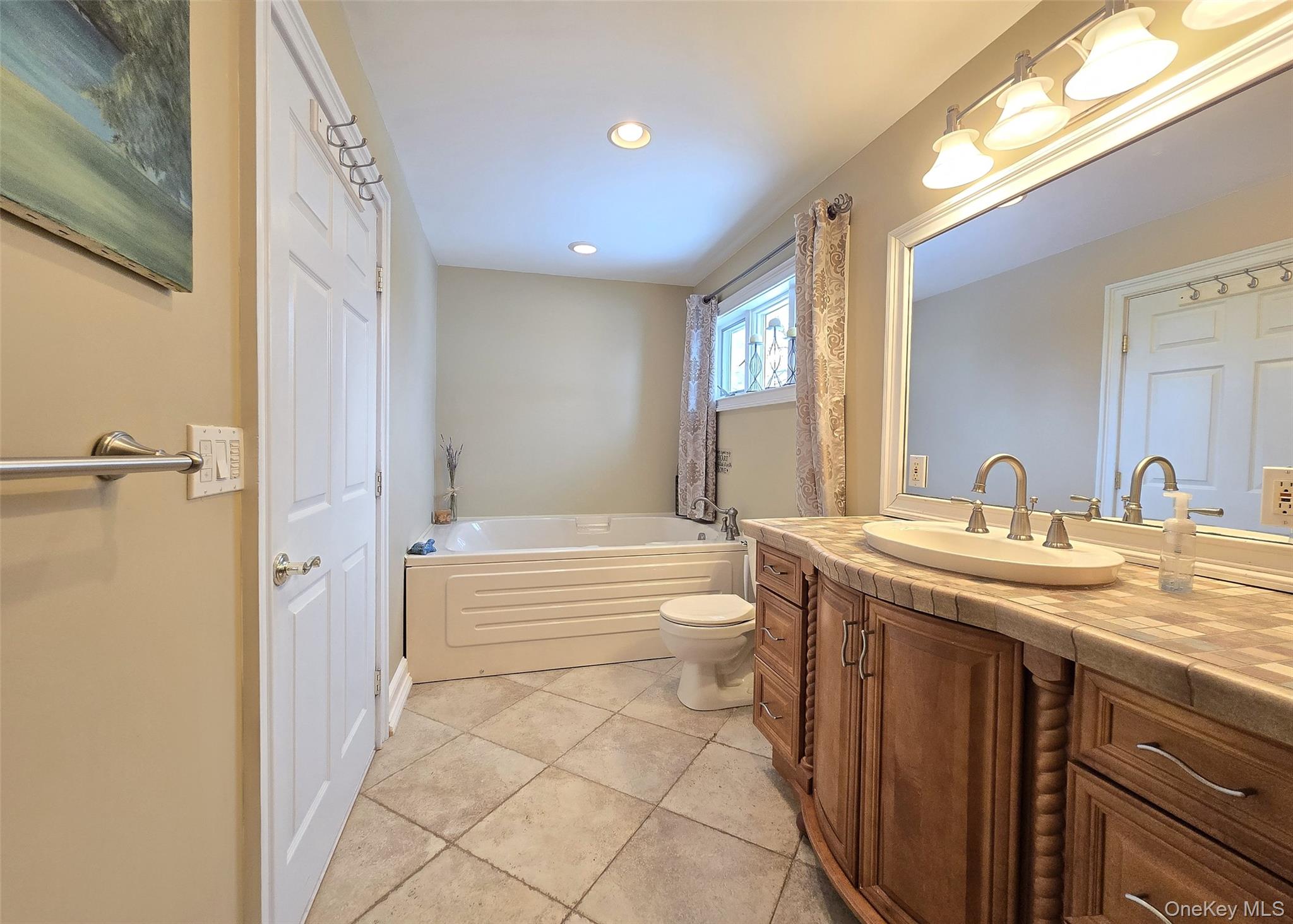 46 Harvest Lane Commack, NY 11725 - Photo 20 of 40 a bathroom with a granite countertop sink a toilet and bathtub
