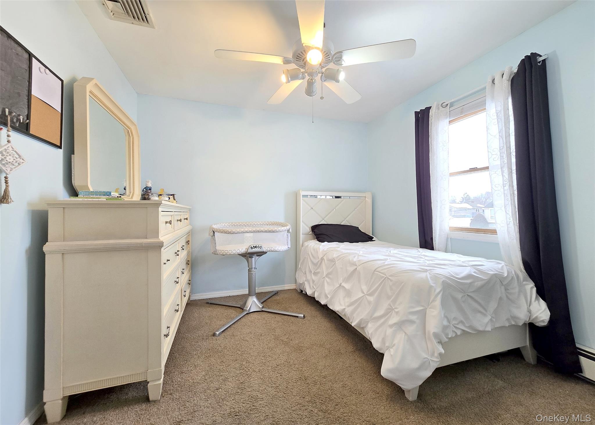 46 Harvest Lane Commack, NY 11725 - Photo 27 of 40 a bedroom with a bed and a chandelier