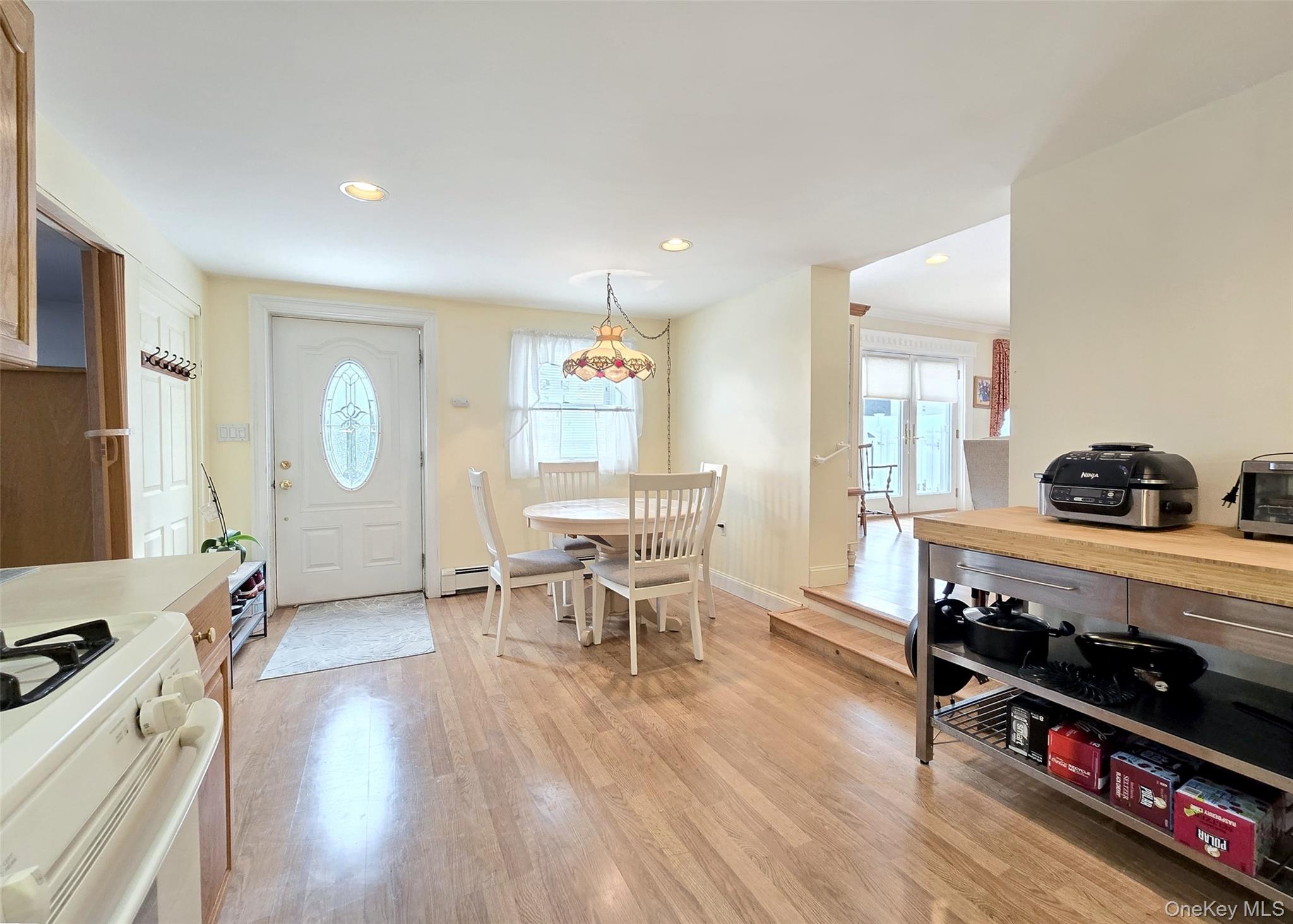 46 Harvest Lane Commack, NY 11725 - Photo 33 of 40 a living room with furniture a dining table wooden floor and a large window