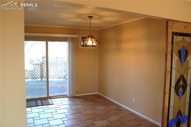 8340 Piute Road Colorado Springs, CO 80926 - Photo 10 of 48 Dining area with ornamental molding and a textured ceiling