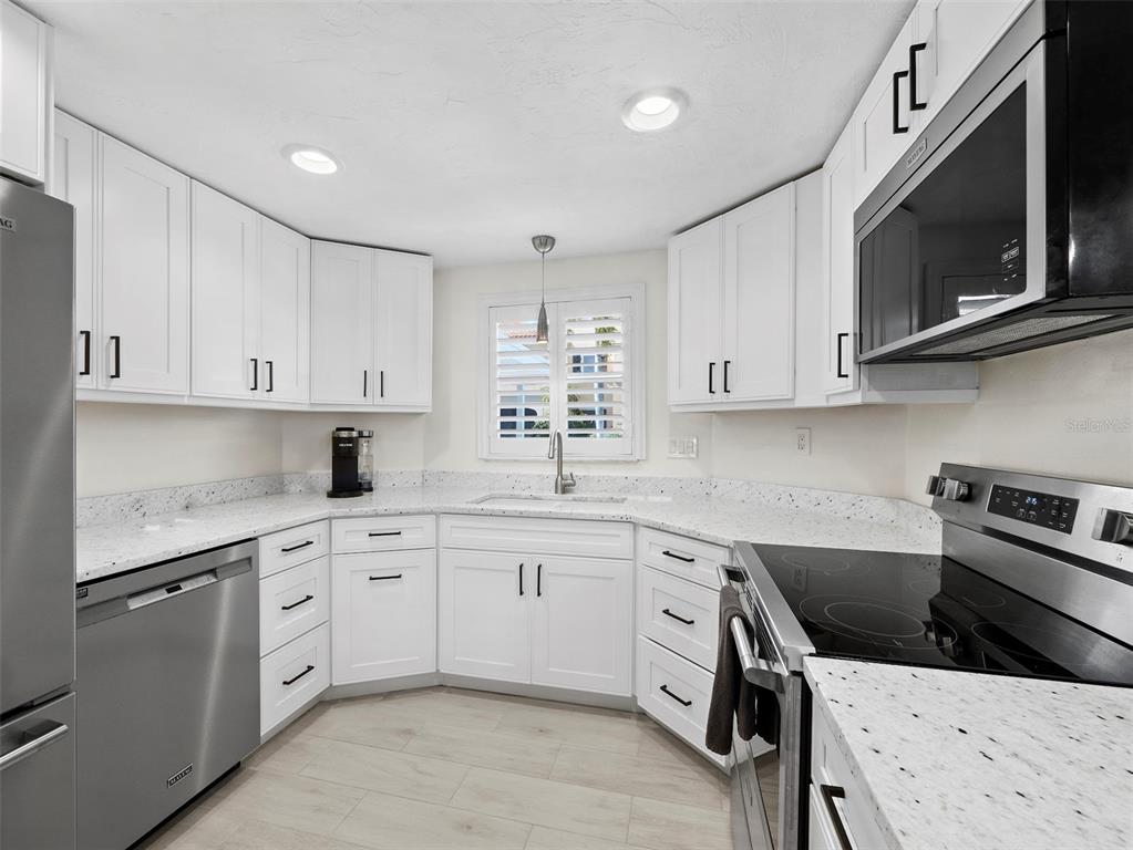 726 Jungle Queen Way Longboat Key, FL 34228 - Photo 12 of 43 a kitchen with a sink stove and microwave
