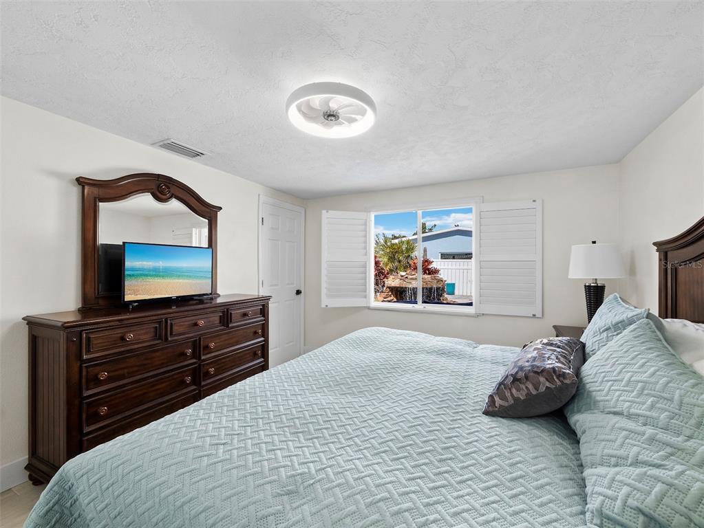 726 Jungle Queen Way Longboat Key, FL 34228 - Photo 20 of 43 a bedroom with a bed and a flat screen television
