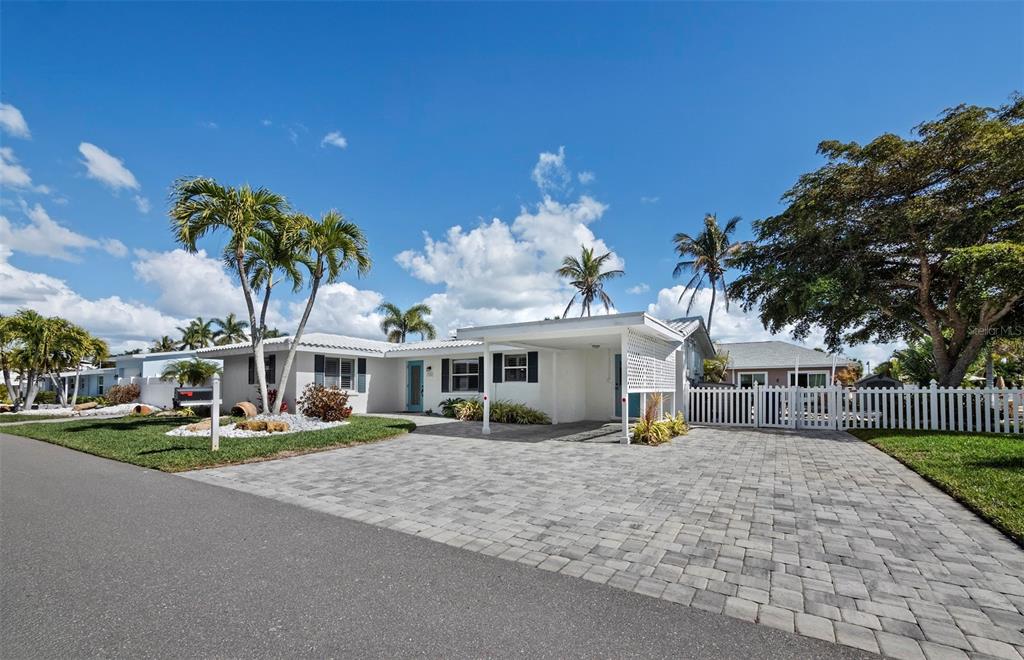 726 Jungle Queen Way Longboat Key, FL 34228 - Photo 39 of 43 a view of a white house with a big yard and potted plants