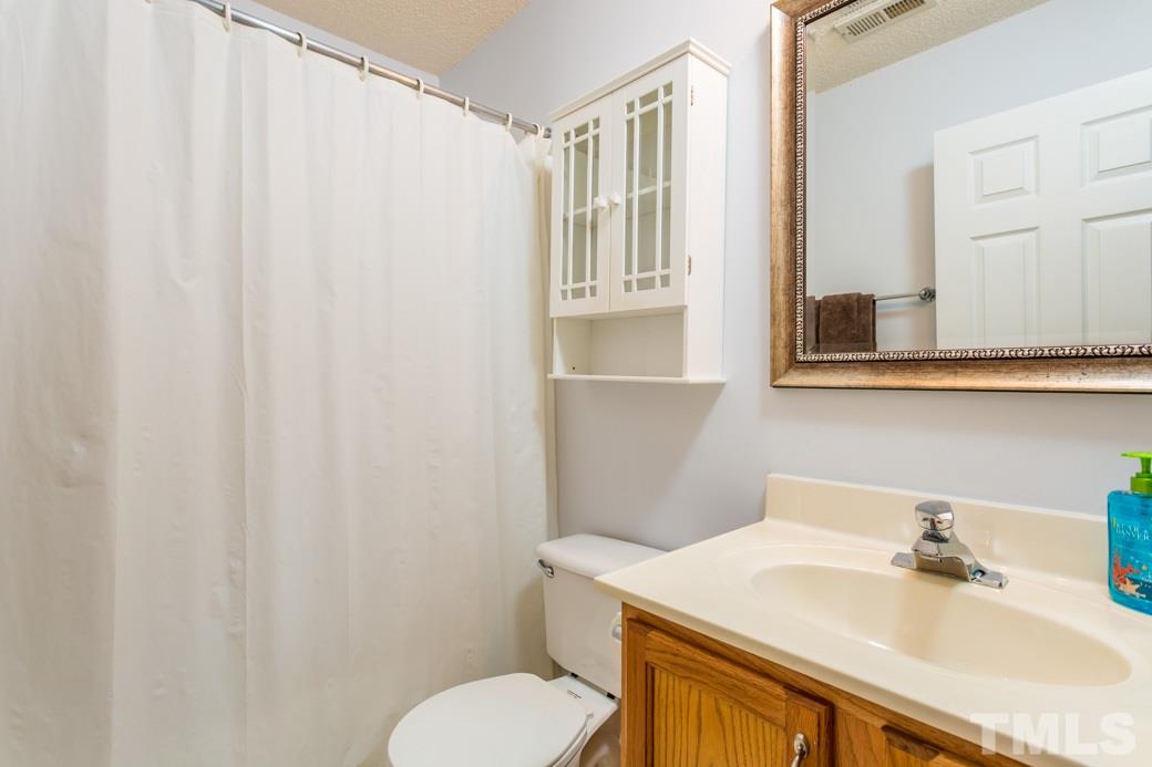 8620 Erinsbrook Drive Raleigh, NC 27617 - Photo 17 of 25 a bathroom with a sink toilet and mirror