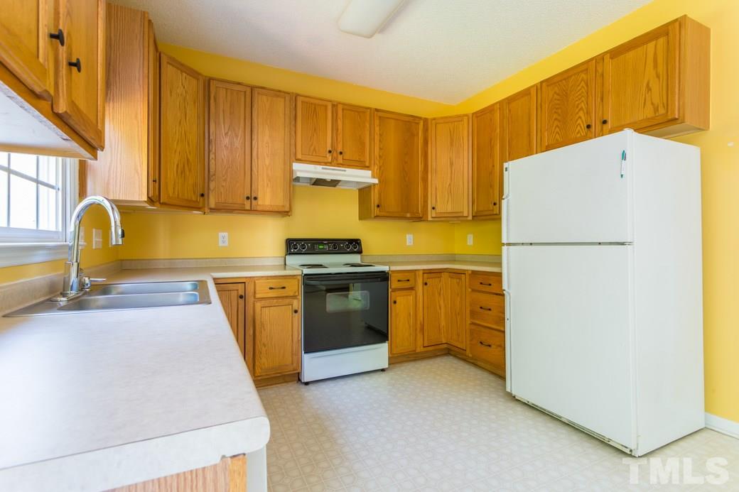 8620 Erinsbrook Drive Raleigh, NC 27617 - Photo 6 of 25 a kitchen with a refrigerator a stove a sink dishwasher and cabinets