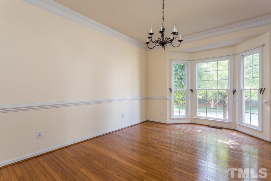 8620 Erinsbrook Drive Raleigh, NC 27617 - Photo 7 of 25 wooden floor in an empty room with a window