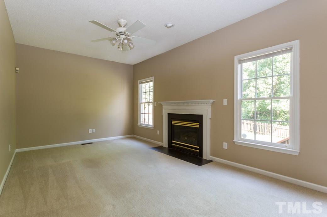 8620 Erinsbrook Drive Raleigh, NC 27617 - Photo 9 of 25 an empty room with windows and fireplace