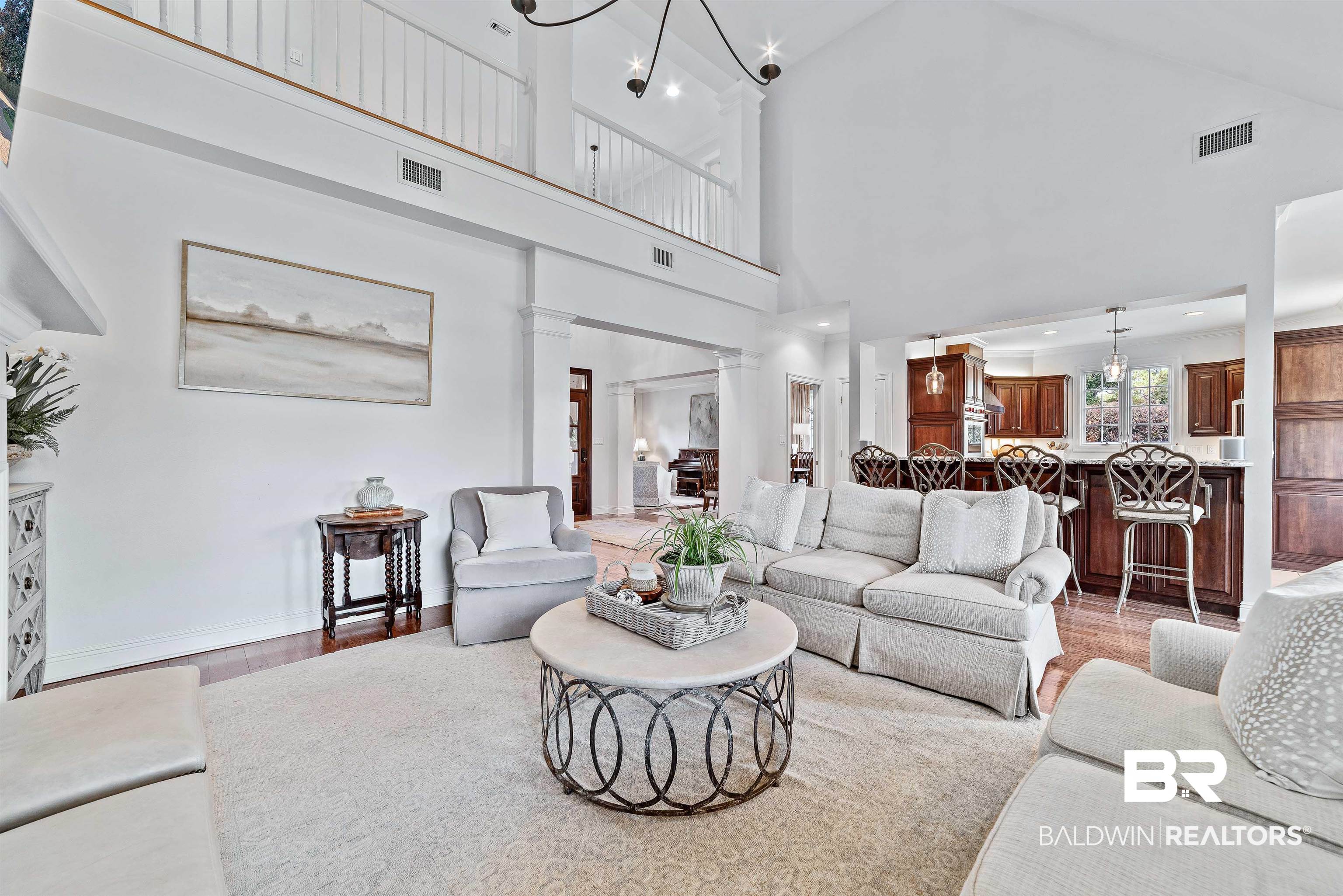 6630 East Quarry Drive Elberta, AL 36530 - Photo 6 of 63 Living room with light wood-style flooring, a chandelier, high vaulted ceiling, and ornate columns