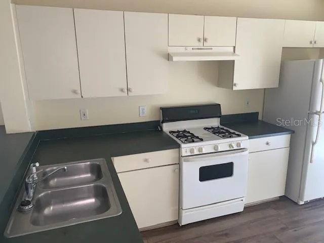 a white stove top oven sitting inside of a kitchen