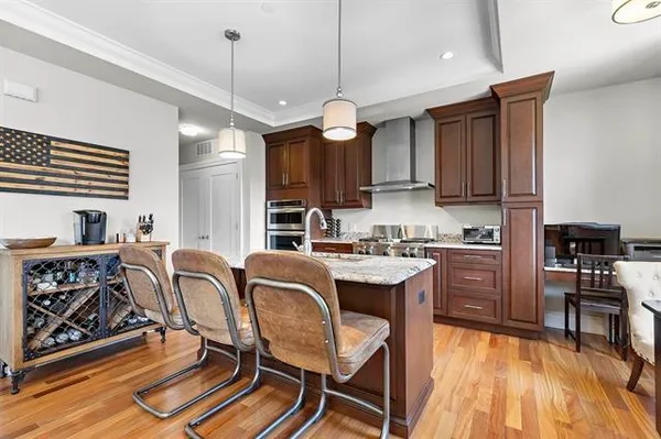 a kitchen with granite countertop a stove a sink a dining table and chairs