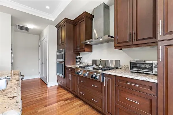 a kitchen with stainless steel appliances granite countertop a stove and a wooden cabinets