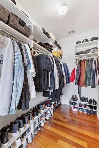 a view of walk in closet with clothes and shoes