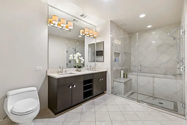 a spacious bathroom with a granite countertop sink a toilet and a mirror