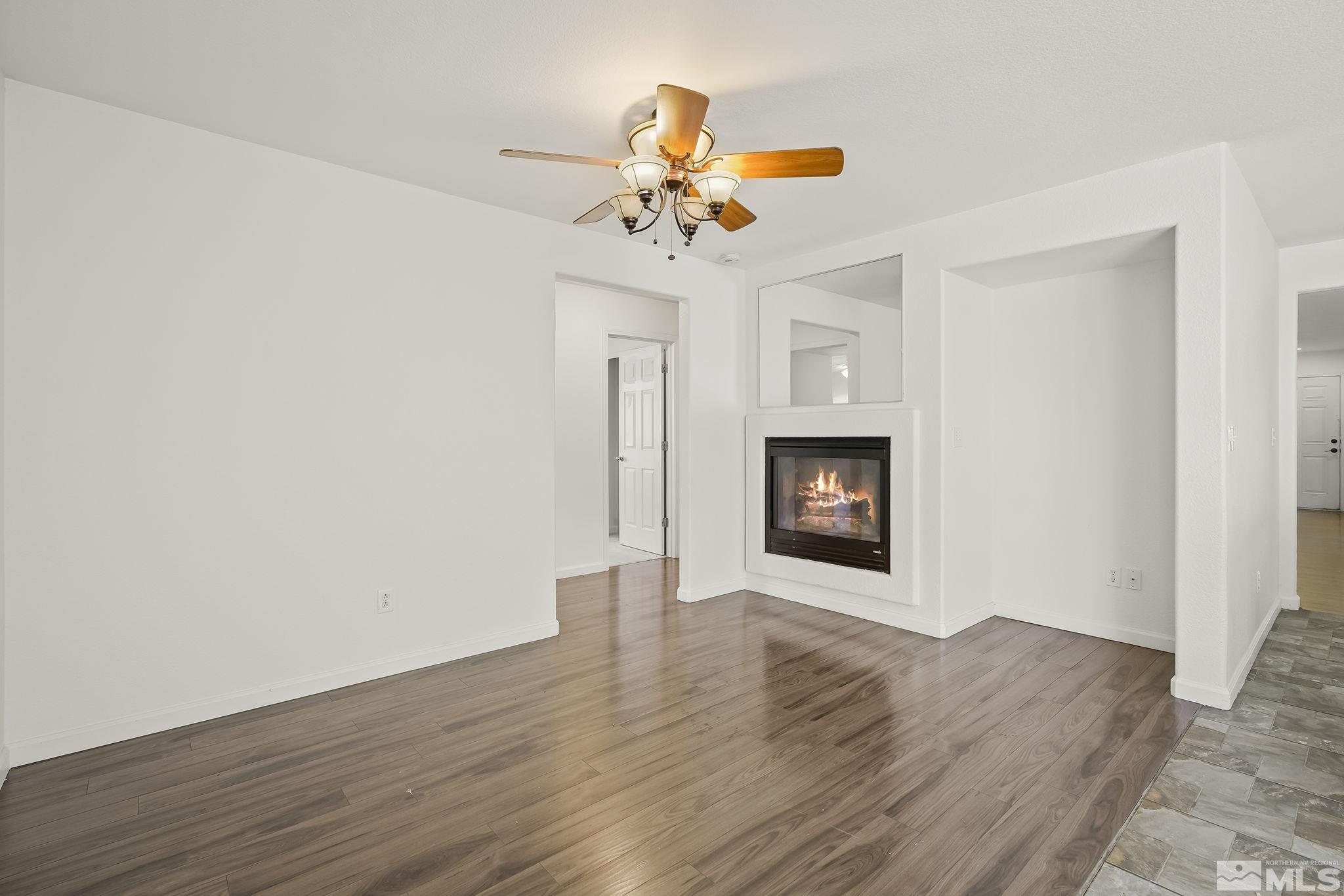 7859 Tulear Street Reno, NV 89506 - Photo 8 of 19 a view of an empty room with wooden floor and a fireplace