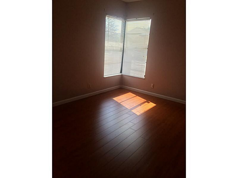 21080 Woodspring Avenue Boca Raton, FL 33428 - Photo 15 of 20 a view of an empty room with wooden floor and a window