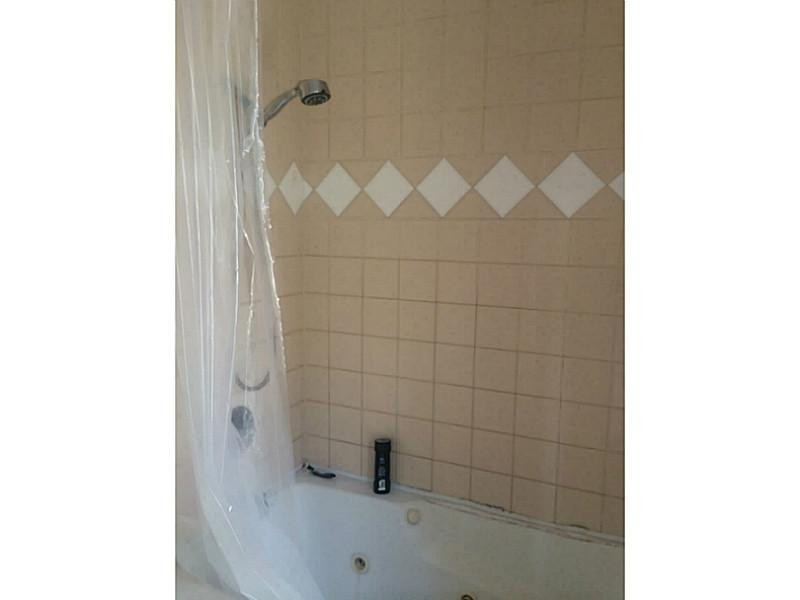 21080 Woodspring Avenue Boca Raton, FL 33428 - Photo 18 of 20 a bathroom with a white bathtub