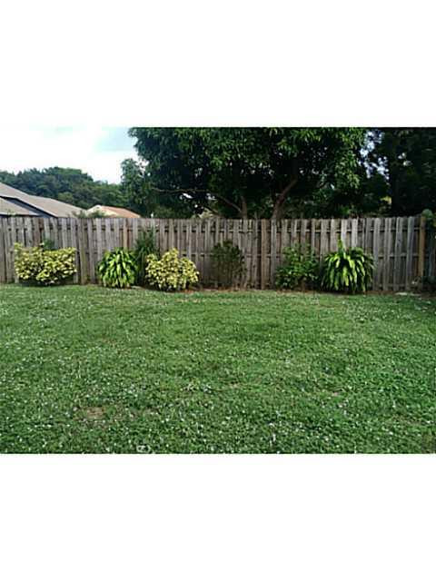 21080 Woodspring Avenue Boca Raton, FL 33428 - Photo 8 of 20 a view of a green yard with wooden fence
