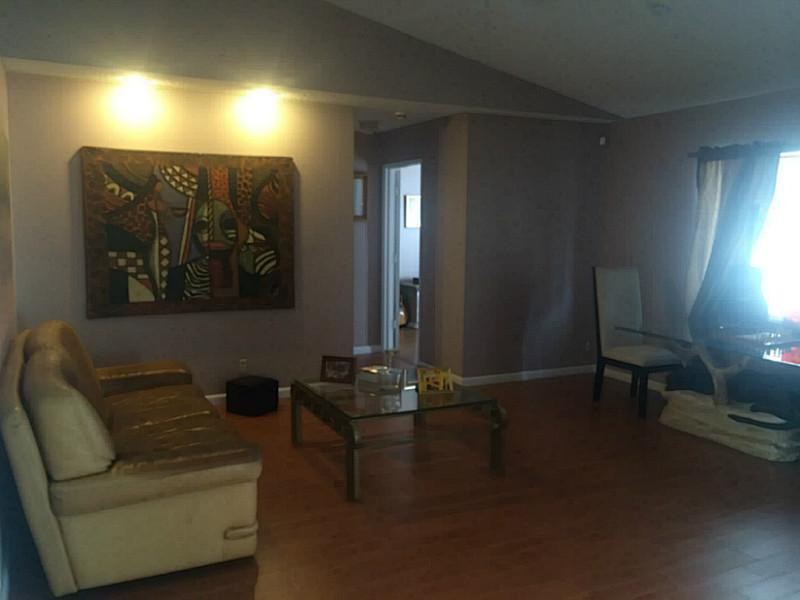 21080 Woodspring Avenue Boca Raton, FL 33428 - Photo 9 of 20 a living room with furniture and a lamp