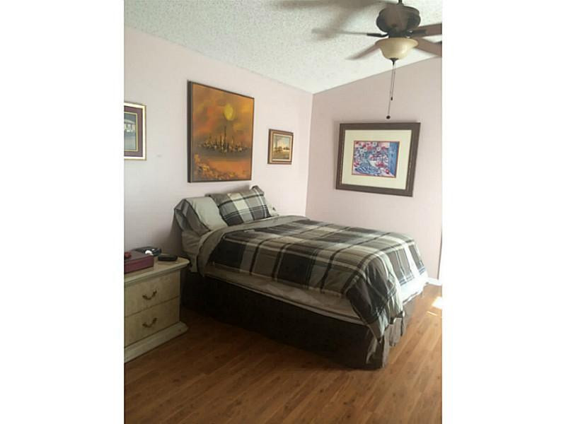 21080 Woodspring Avenue Boca Raton, FL 33428 - Photo 10 of 20 a bedroom with a bed and a painting on the wall