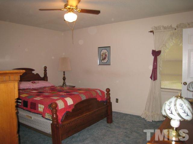 3712 Allen Street West Raleigh, NC 27603 - Photo 12 of 23 a bedroom with a bed and a chandelier