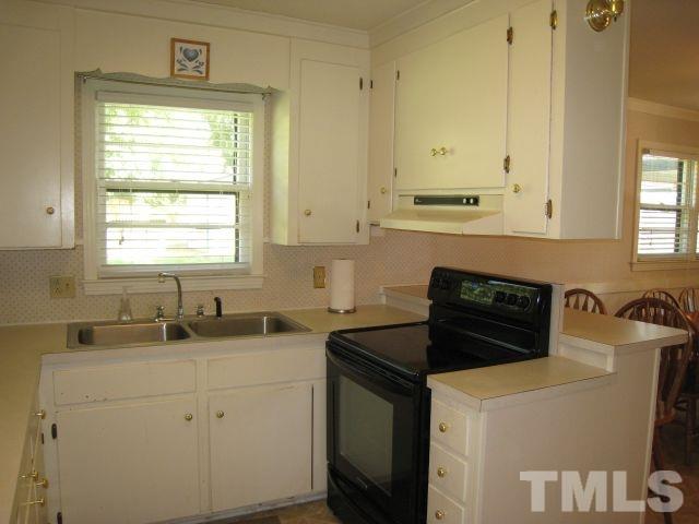 3712 Allen Street West Raleigh, NC 27603 - Photo 6 of 23 a kitchen with white cabinets sink and window