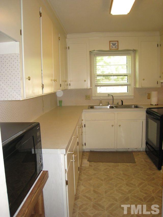 3712 Allen Street West Raleigh, NC 27603 - Photo 9 of 23 a kitchen with stainless steel appliances a stove a sink a stove a microwave a counter space and cabinets