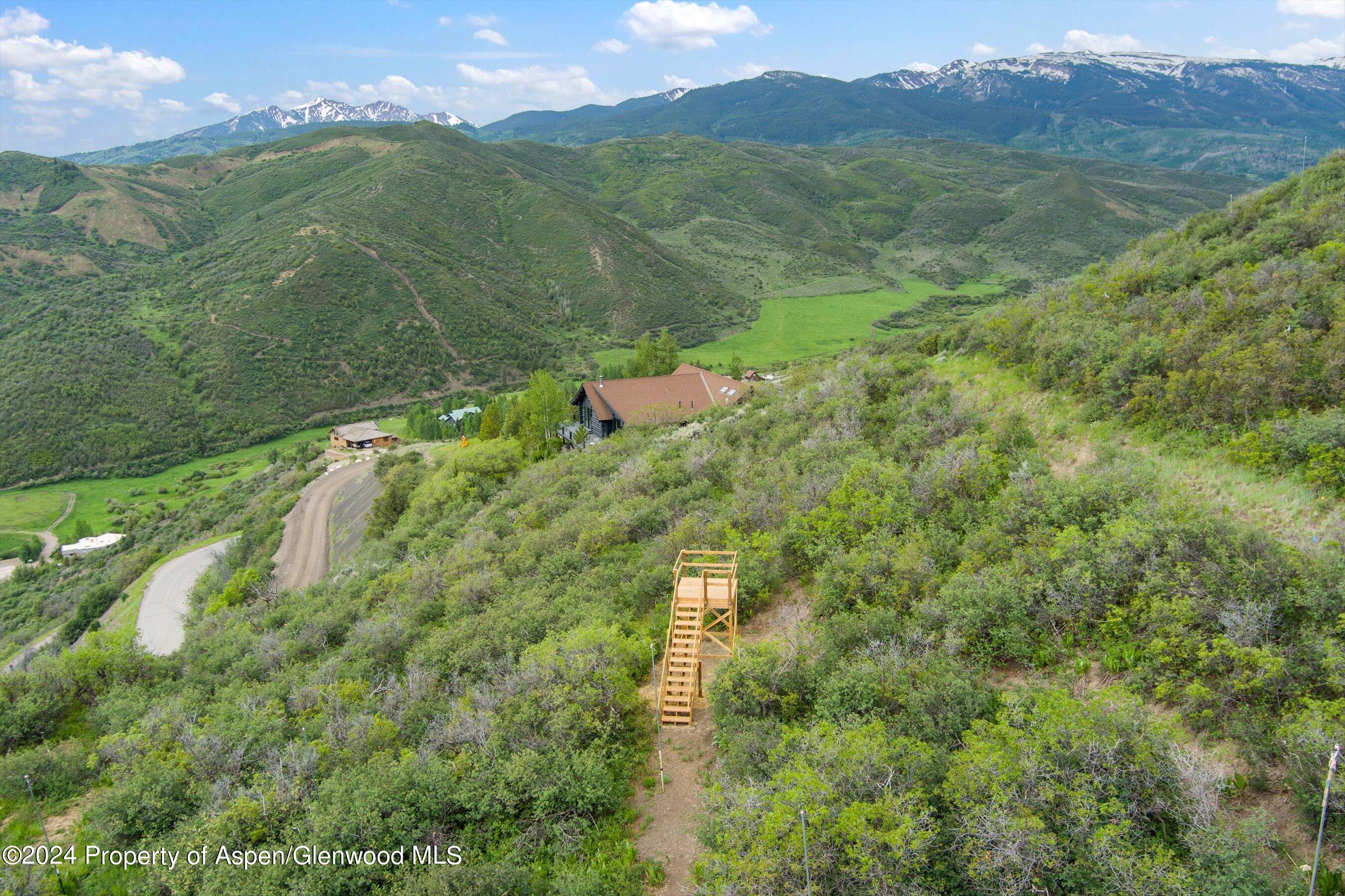 148 Tabula Rasa Lane Aspen, CO 81611 - Photo 14 of 15 a aerial view of a houses with a lush green hillside