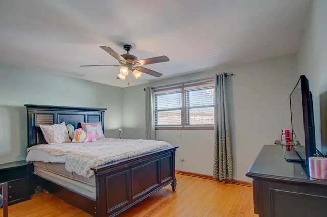 a bedroom with a large bed and a flat tv screen on dresser