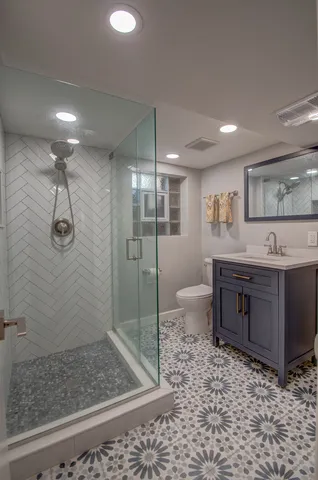 a bathroom with a granite countertop sink a toilet and shower