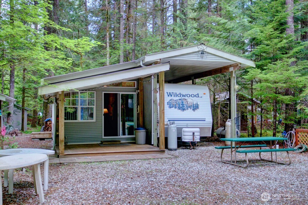 a view of a chair and table in backyard of the house