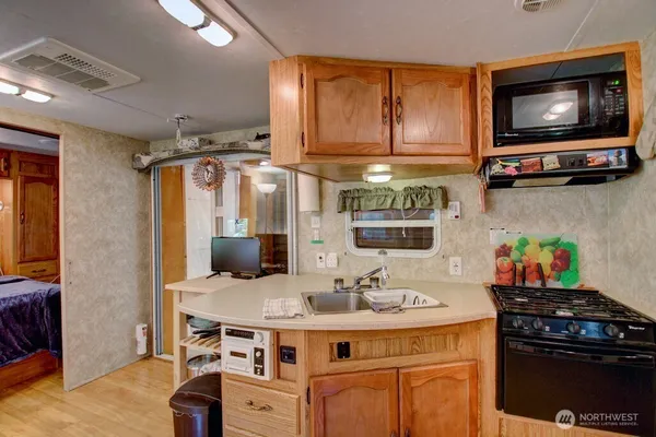 a kitchen with stainless steel appliances a stove a sink and a microwave