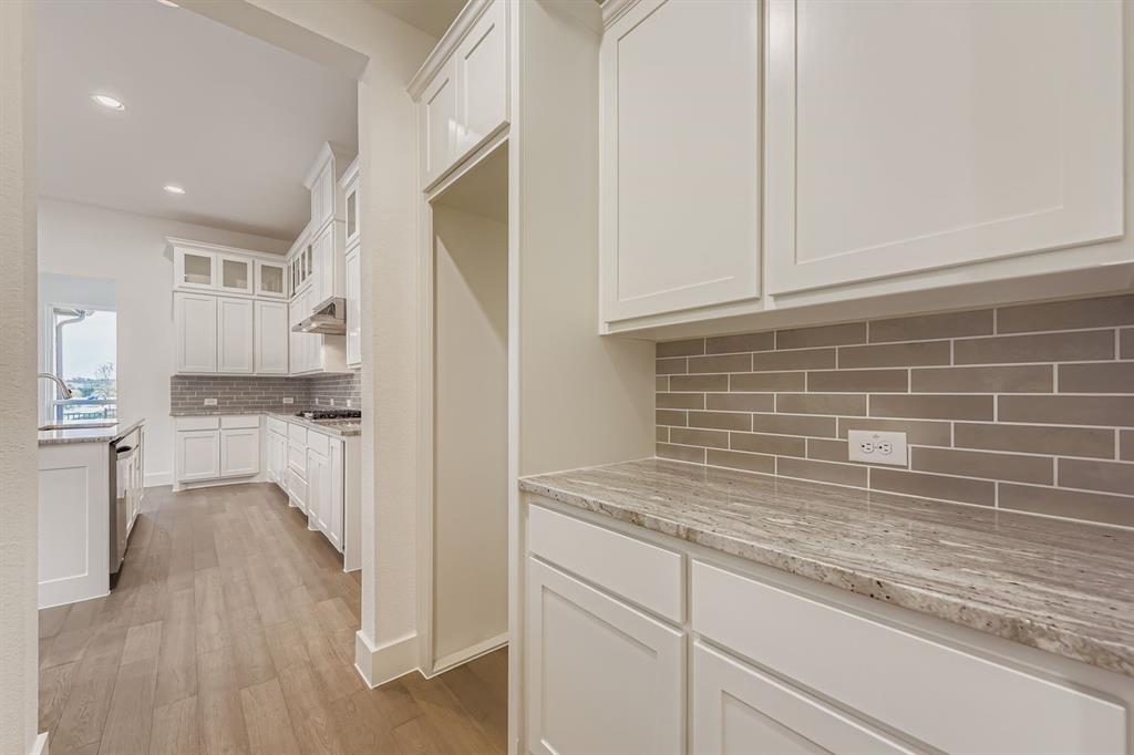 154 Longhorn Bend Rhome, TX 76078 - Photo 14 of 25 a kitchen with granite countertop white cabinets and white appliances