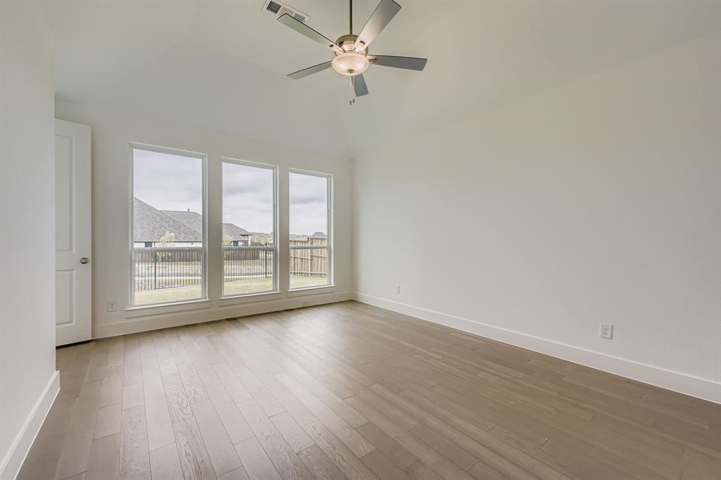 154 Longhorn Bend Rhome, TX 76078 - Photo 16 of 25 an empty room with wooden floor fan and windows