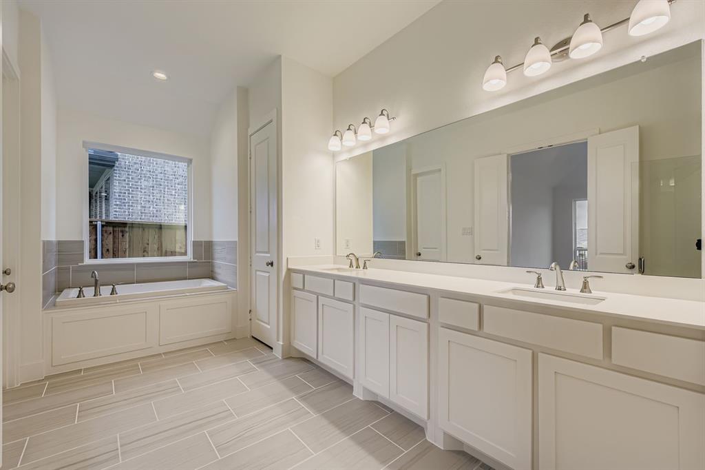 154 Longhorn Bend Rhome, TX 76078 - Photo 17 of 25 a bathroom with a tub sink double vanity and mirror