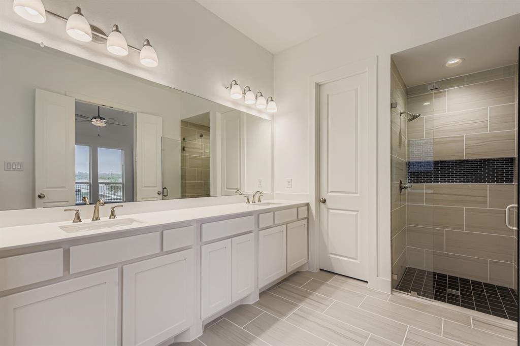 154 Longhorn Bend Rhome, TX 76078 - Photo 18 of 25 a spacious bathroom with a double vanity sink a large mirror and a shower