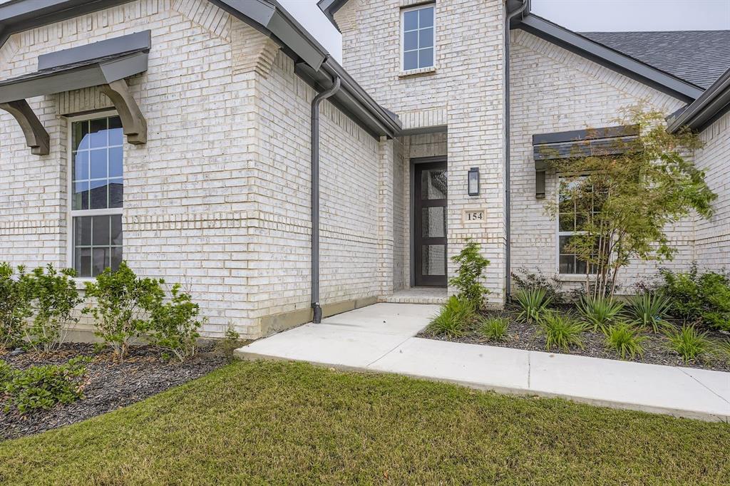 154 Longhorn Bend Rhome, TX 76078 - Photo 2 of 25 a front view of a house with garden