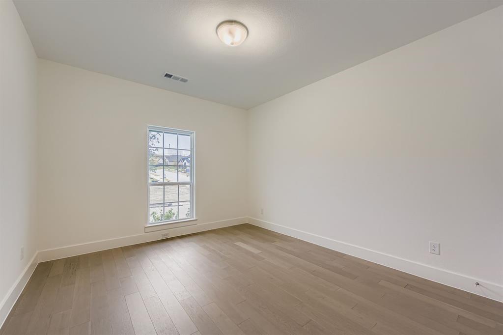 154 Longhorn Bend Rhome, TX 76078 - Photo 21 of 25 an empty room with wooden floor and windows