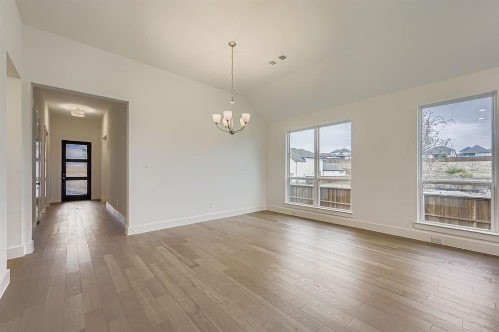 154 Longhorn Bend Rhome, TX 76078 - Photo 7 of 25 a view of an empty room with wooden floor and a window